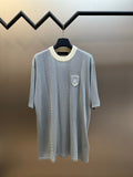 Light blue knit polo shirt with off-white ribbed collar and short sleeves