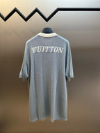 Light blue knit polo shirt with 'VUITTON' print on back