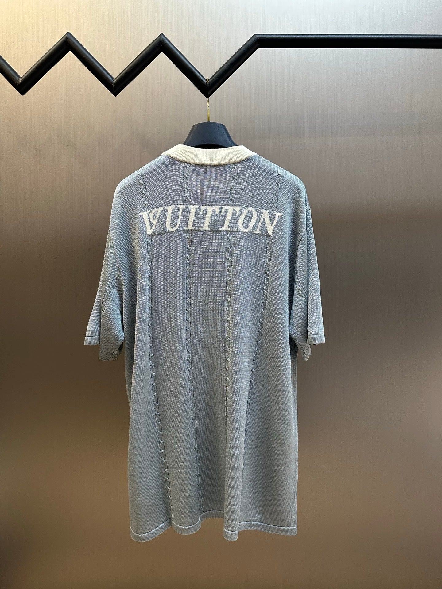 Light blue knit polo shirt with 'VUITTON' print on back