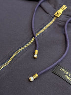 Dark navy hoodie with gold-tone zipper and drawstring aglets