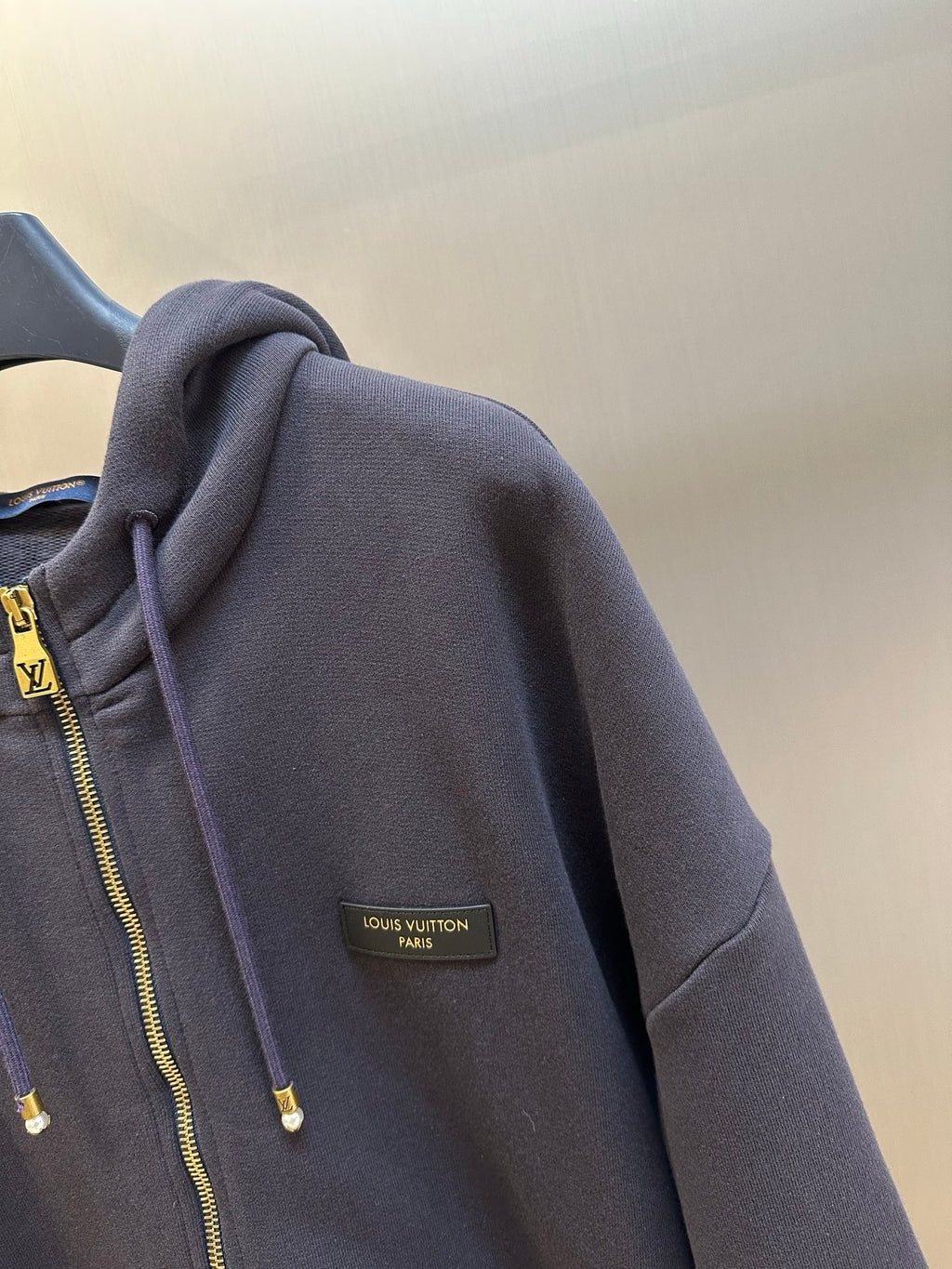 Dark navy hoodie sleeve with Louis Vuitton Paris logo patch