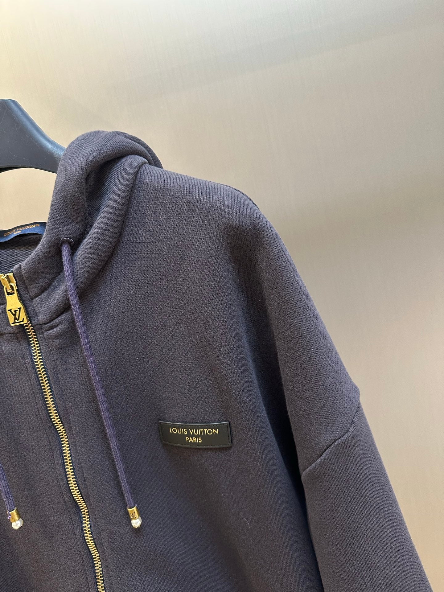 Dark navy hoodie sleeve with Louis Vuitton Paris logo patch