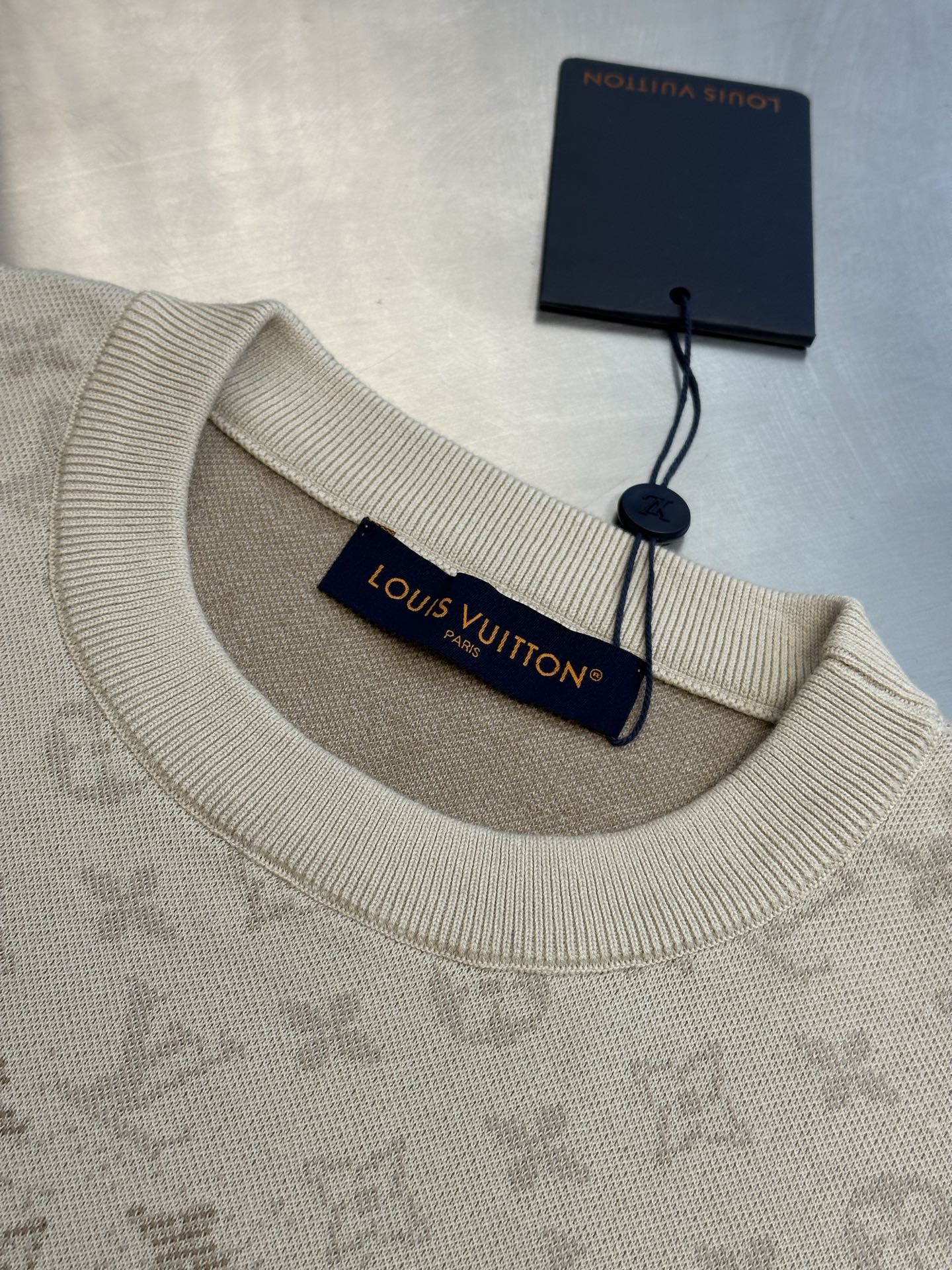 Light beige crewneck sweater with ribbed collar and Louis Vuitton logo tag