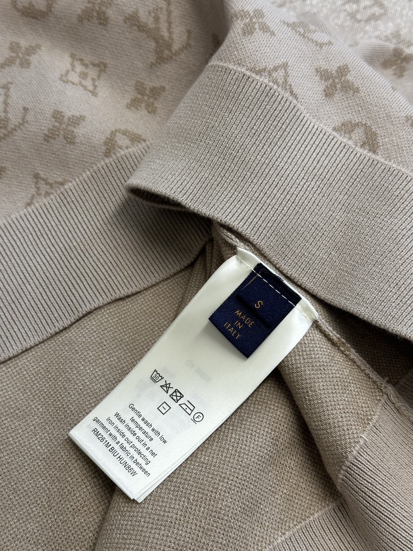 Light beige sweater care label at side seam with Louis Vuitton logo