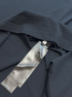 Dark navy T-shirt collar area with metallic hang tag