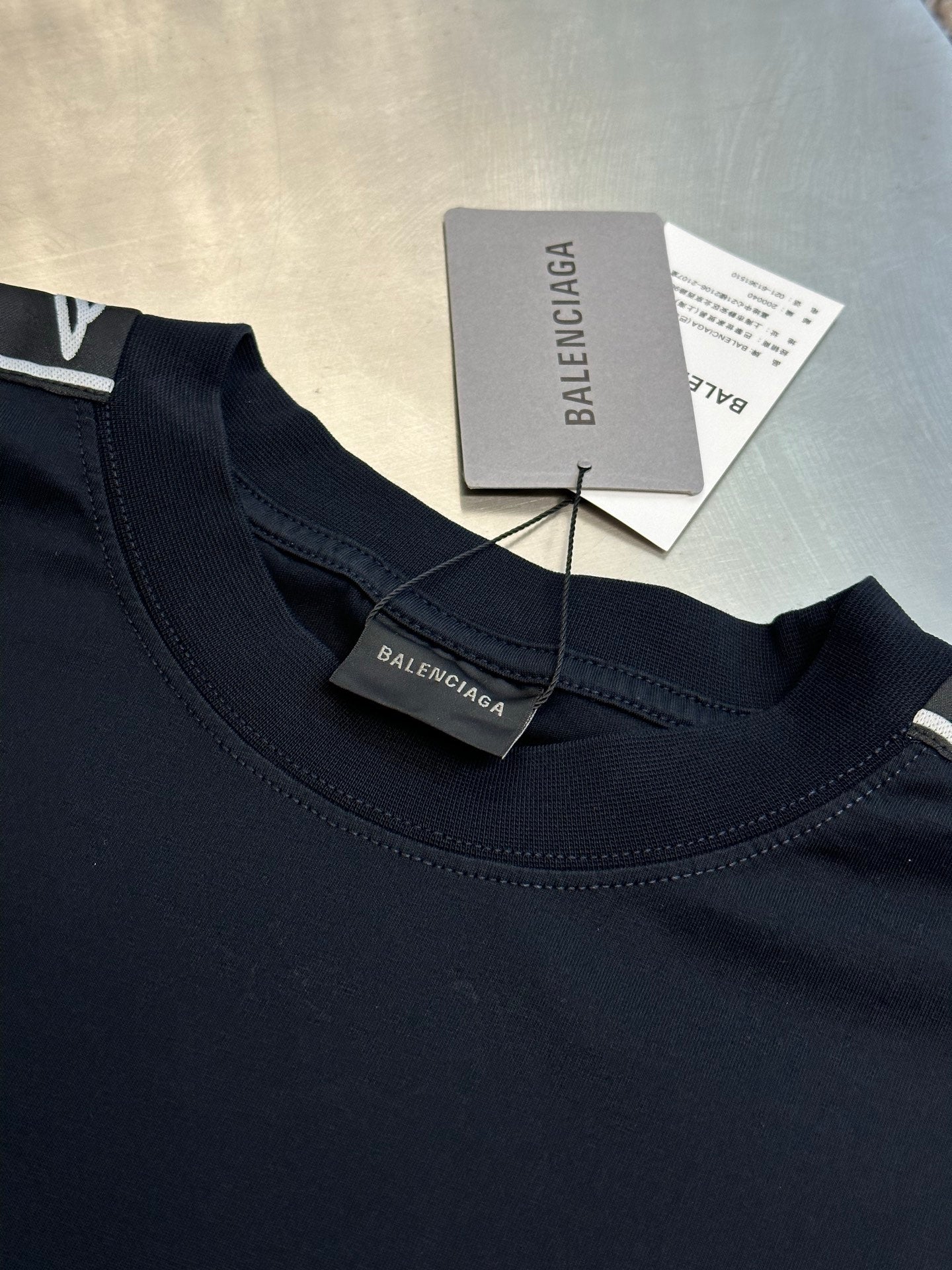 Dark navy crewneck T-shirt neckline with Balenciaga tag and hang tag