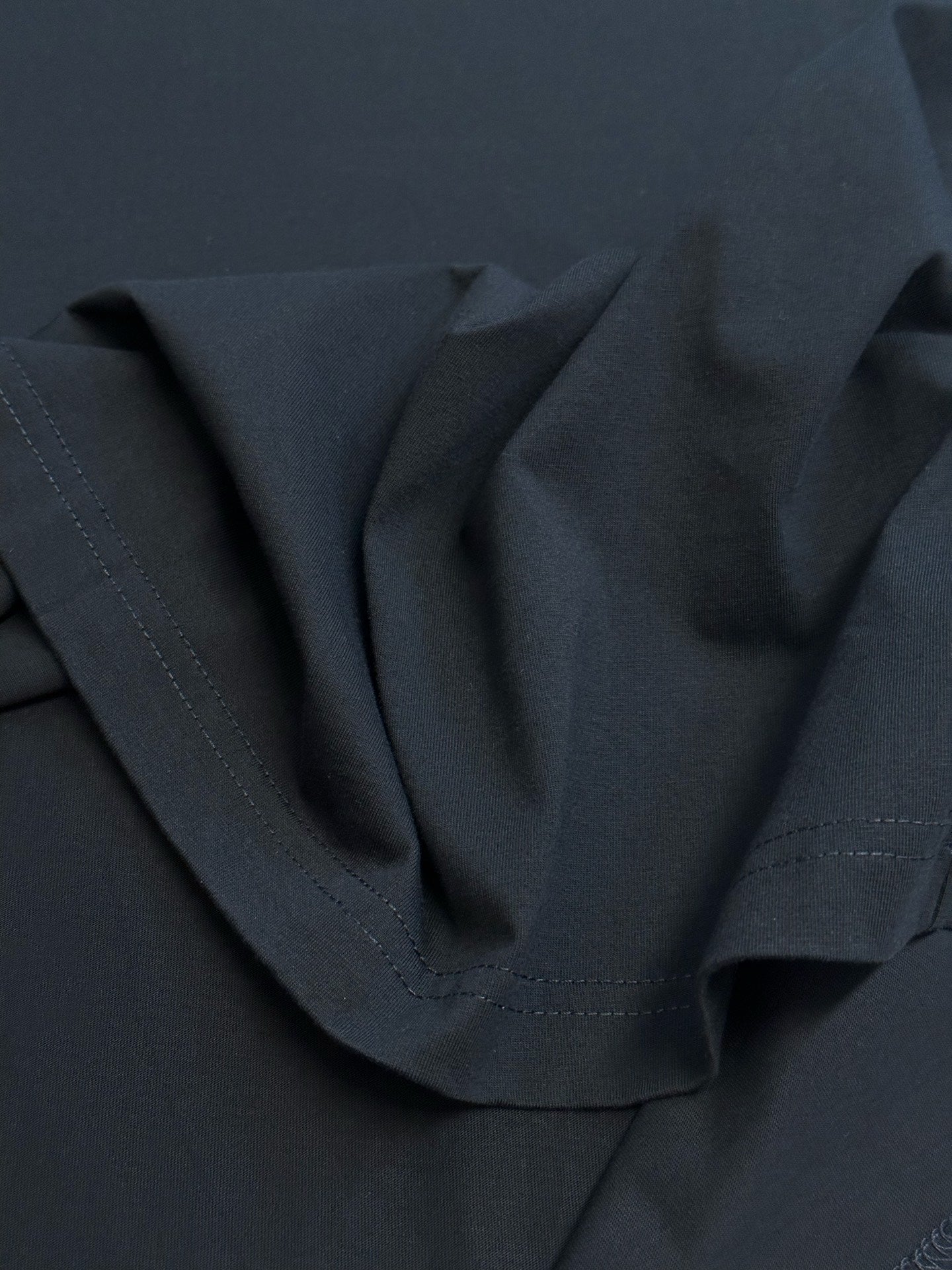 Crewneck T-shirt fabric close-up with curved neckline seam