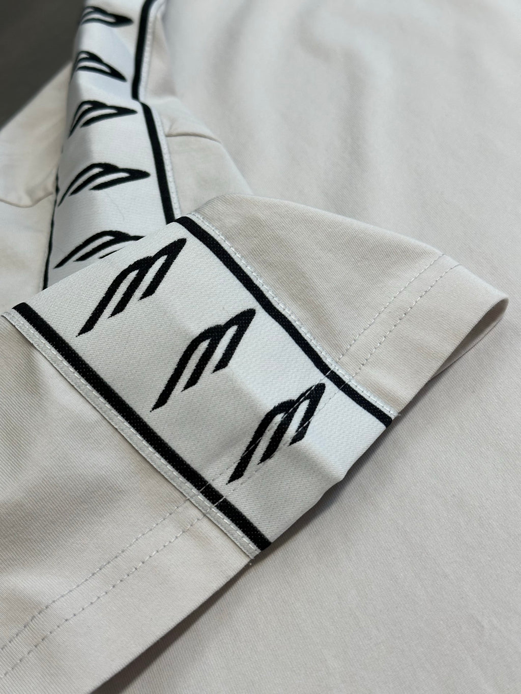 White sleeve cuff with black logo stripe trim