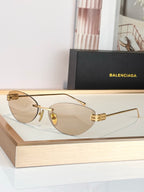 Balenciaga sunglasses with gold frame and light tan lenses, metal hinge detail