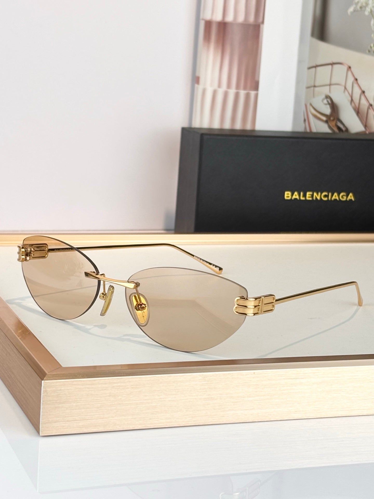 Balenciaga sunglasses with gold frame and light tan lenses, metal hinge detail