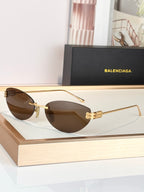 Balenciaga sunglasses with gold frame and brown tinted lenses, round design