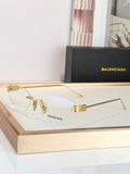 Balenciaga sunglasses with gold frame and clear lenses, metal bridge detail