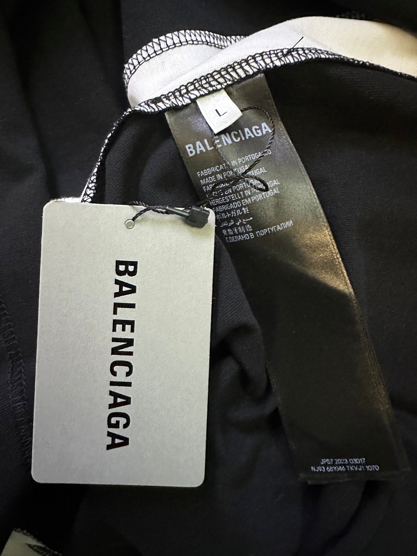 Balenciaga jersey close-up showing neck label, inner size label, and attached hang tag