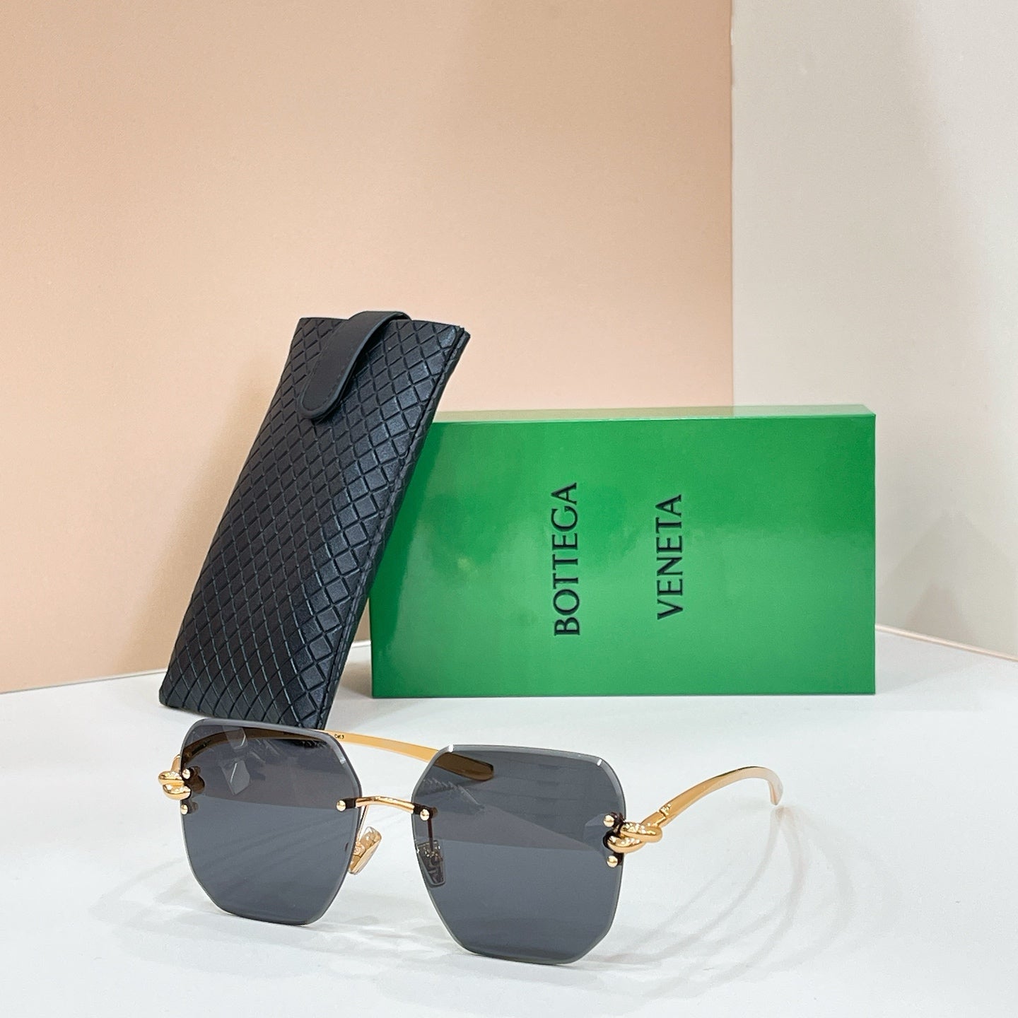 Bottega Veneta sunglasses with gold-tone frame and charcoal tinted lenses