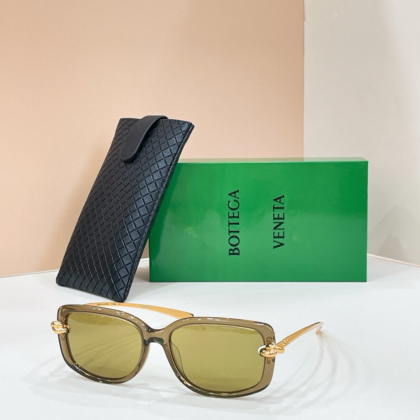Square sunglasses with light tan frame and yellow-tinted lenses, gold-tone details