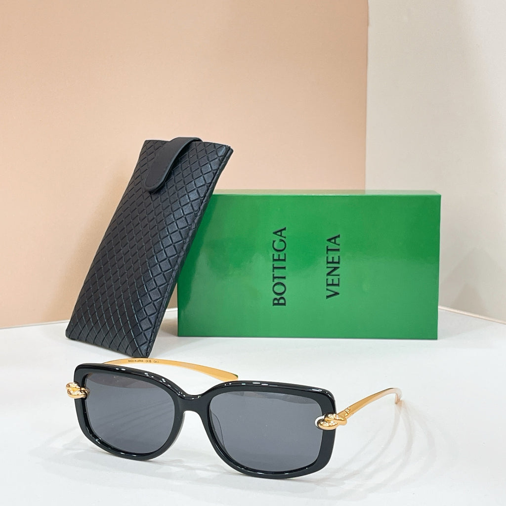 Square sunglasses with black frame and dark gray lenses, gold-tone hinge details