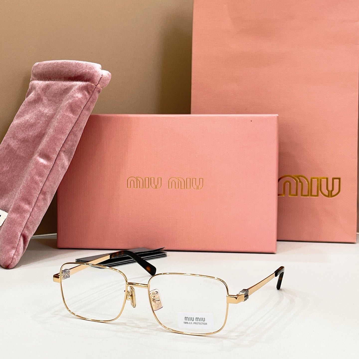 MiuMiu gold-tone rectangular eyeglasses with clear lenses and gold temple tips