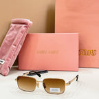 MiuMiu gold-tone rectangular sunglasses with amber gradient lenses and black top-bar detail