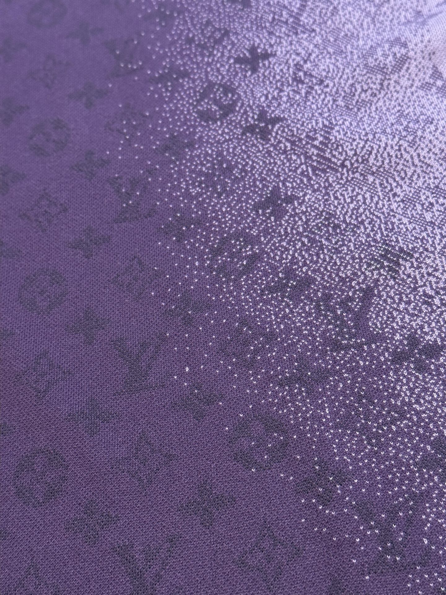 Purple T-shirt fabric close-up with dense textured graphic dots and pattern