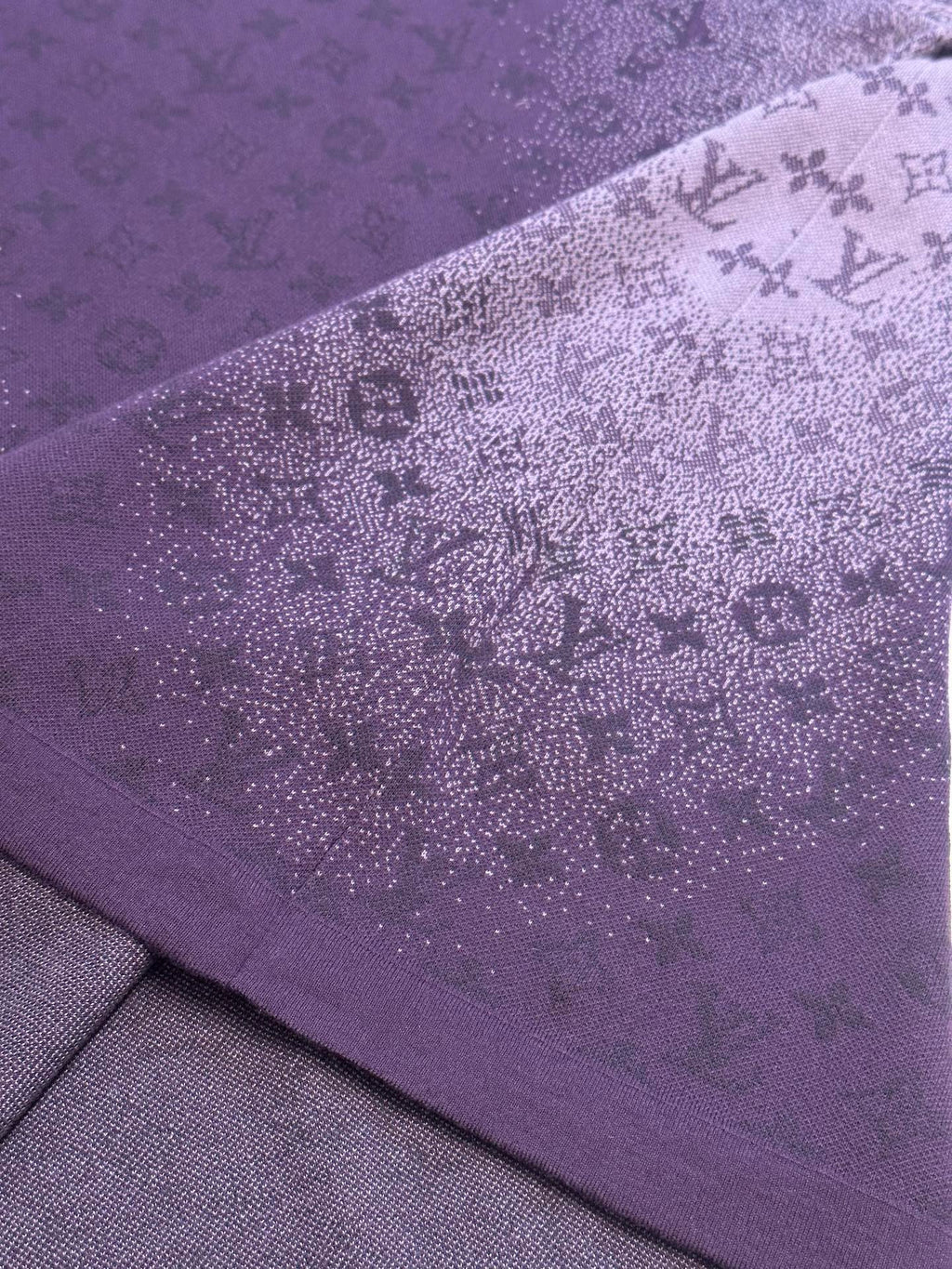Purple T-shirt side fabric close-up with textured allover graphic print