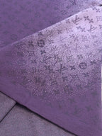 Purple T-shirt side fabric close-up with textured allover graphic print