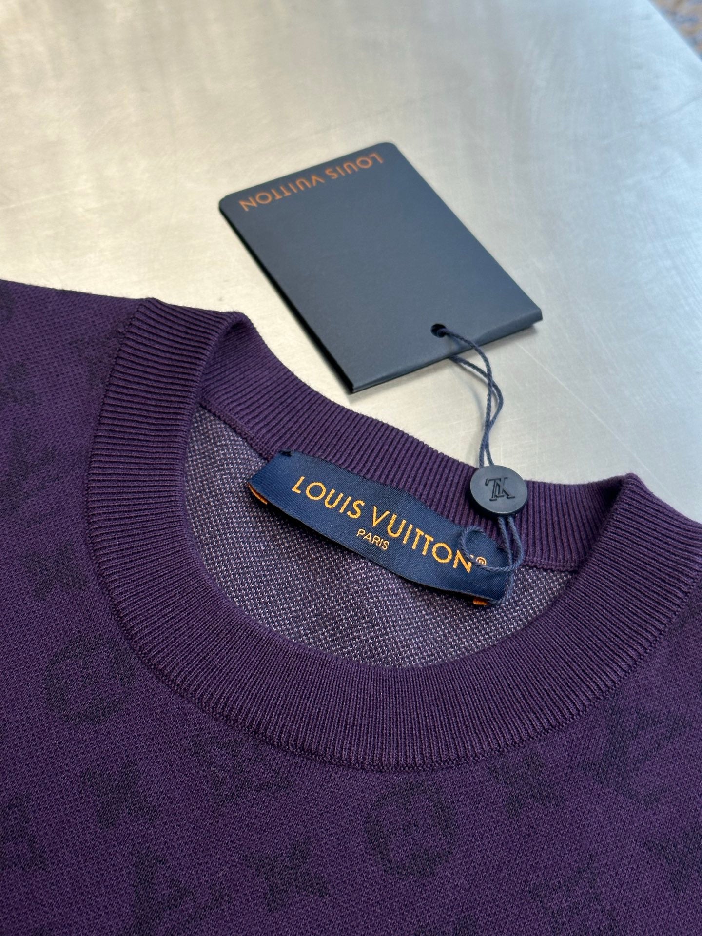 Purple crewneck T-shirt neckline with brand label and hanging tag