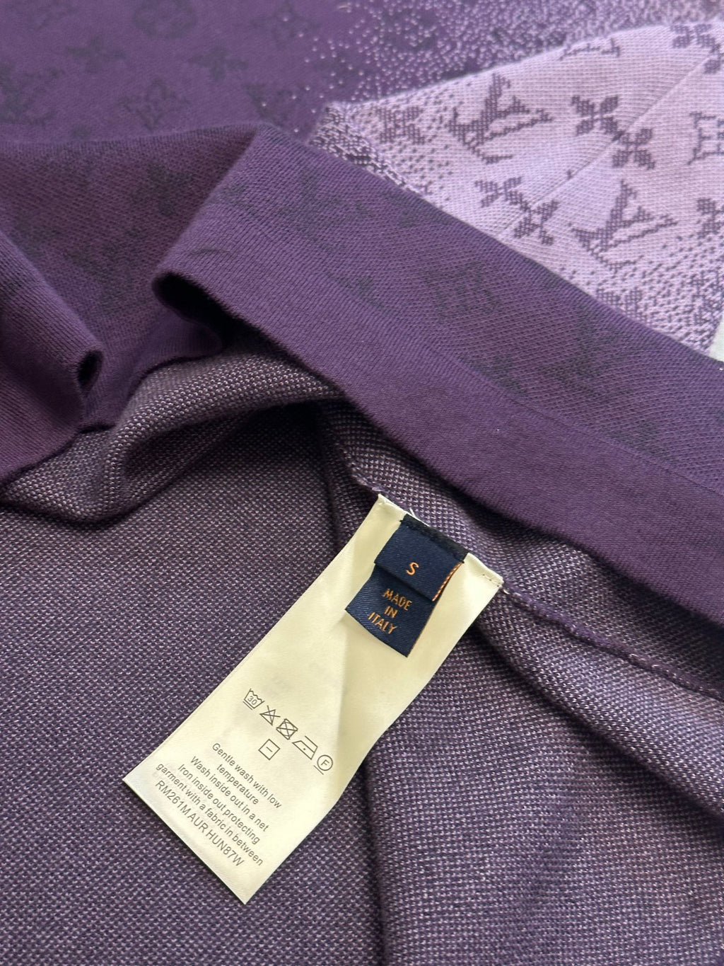 Purple T-shirt detail with woven brand label and care tag on inner fabric
