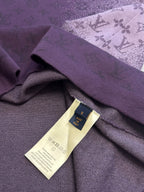 Purple T-shirt detail with woven brand label and care tag on inner fabric