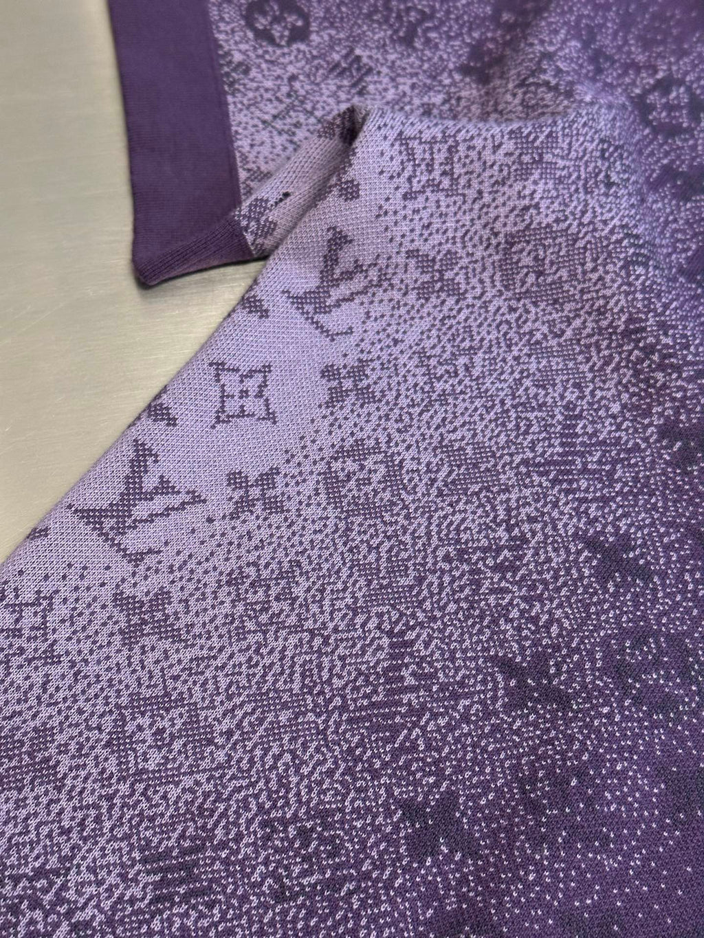 Purple T-shirt fabric with textured allover graphic print, close-up