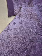 Purple T-shirt fabric with textured allover graphic print, close-up