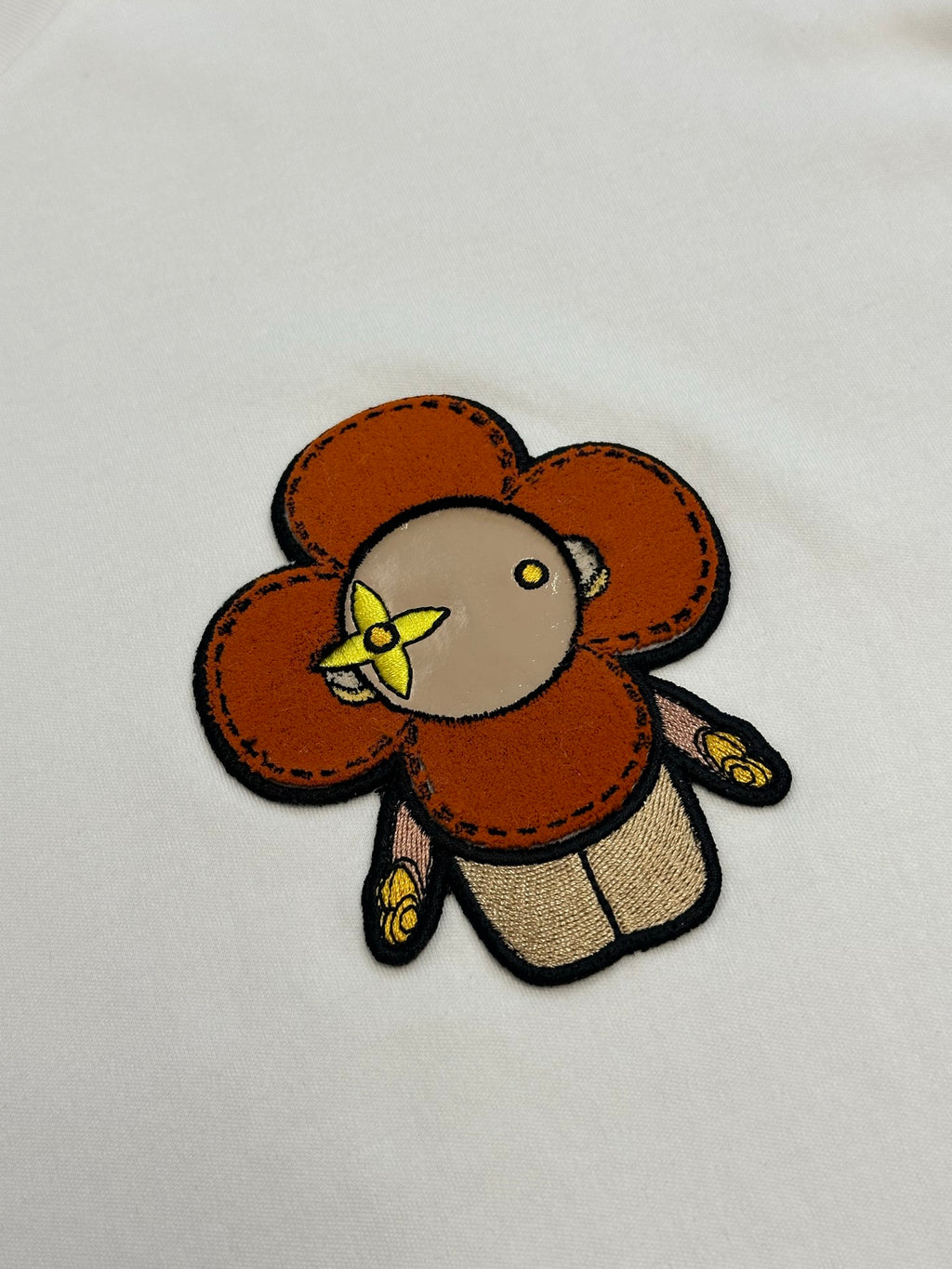 White T-shirt close-up of colorful bear patch embroidery