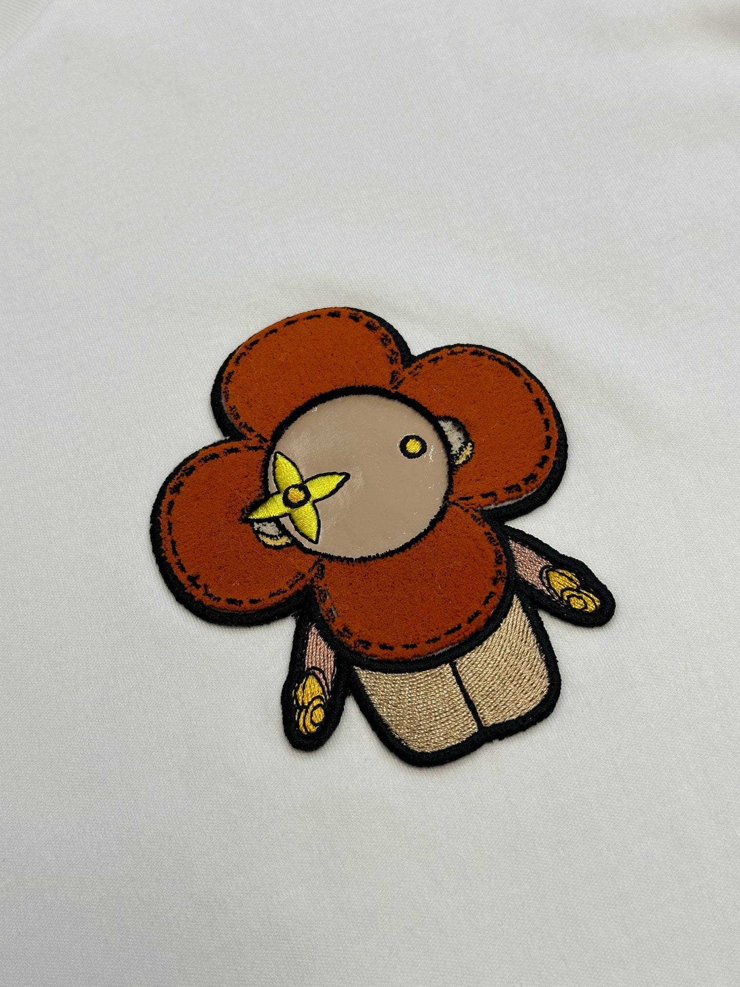 White T-shirt close-up of colorful bear patch embroidery