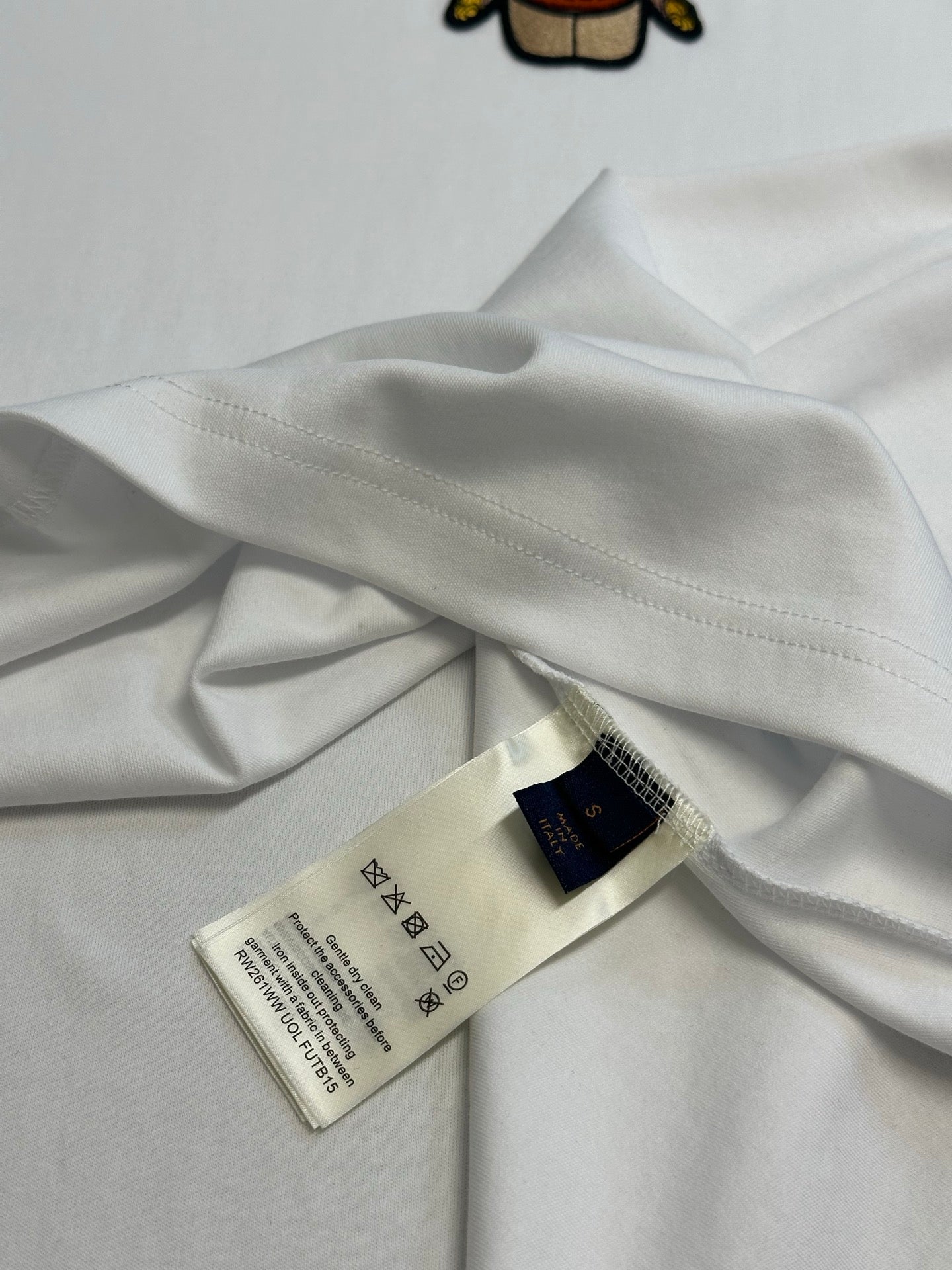 White T-shirt fabric close-up with size and care label near hem
