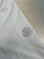 White Moncler T-shirt sleeve with round logo patch near hem.