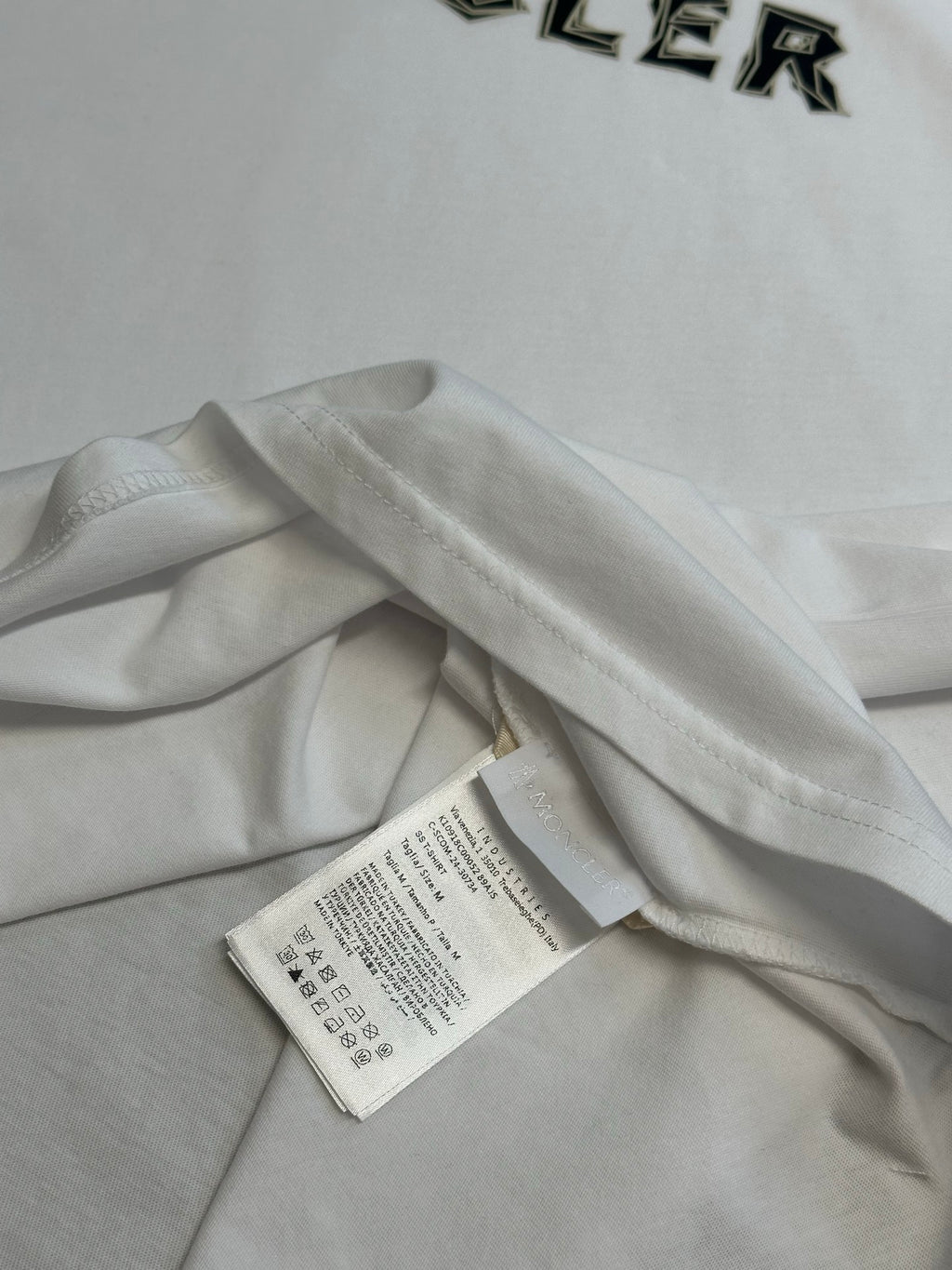 White Moncler T-shirt with hanging size label at neckline.