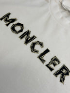 White Moncler T-shirt with black embroidered-style logo lettering close-up.