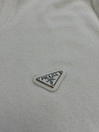 Prada triangular logo patch on white T-shirt fabric