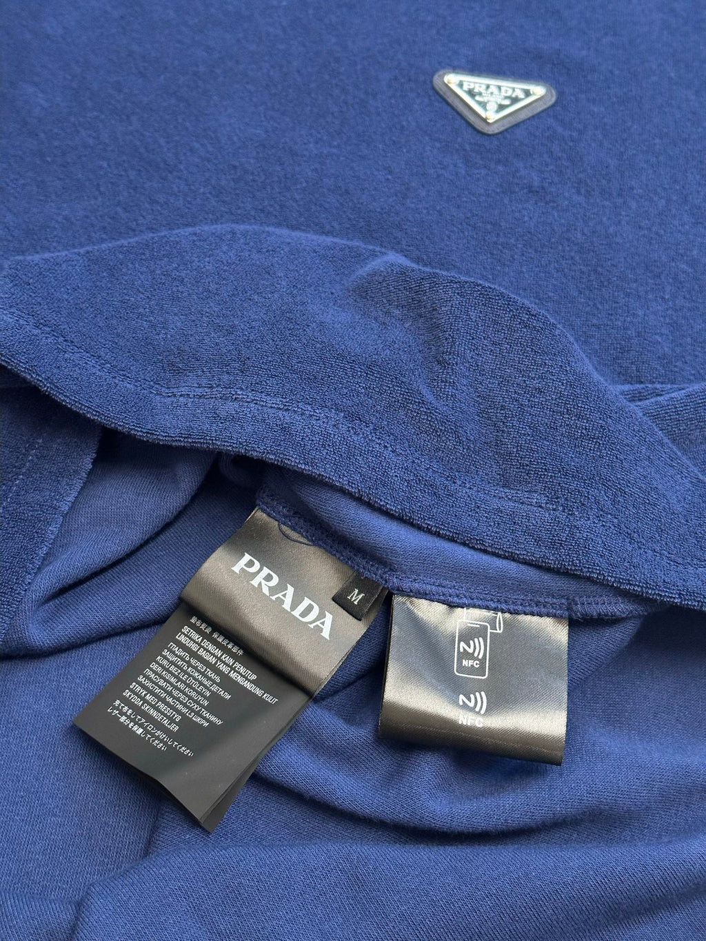 Blue Prada T-shirt hem with interior label and draped collar.