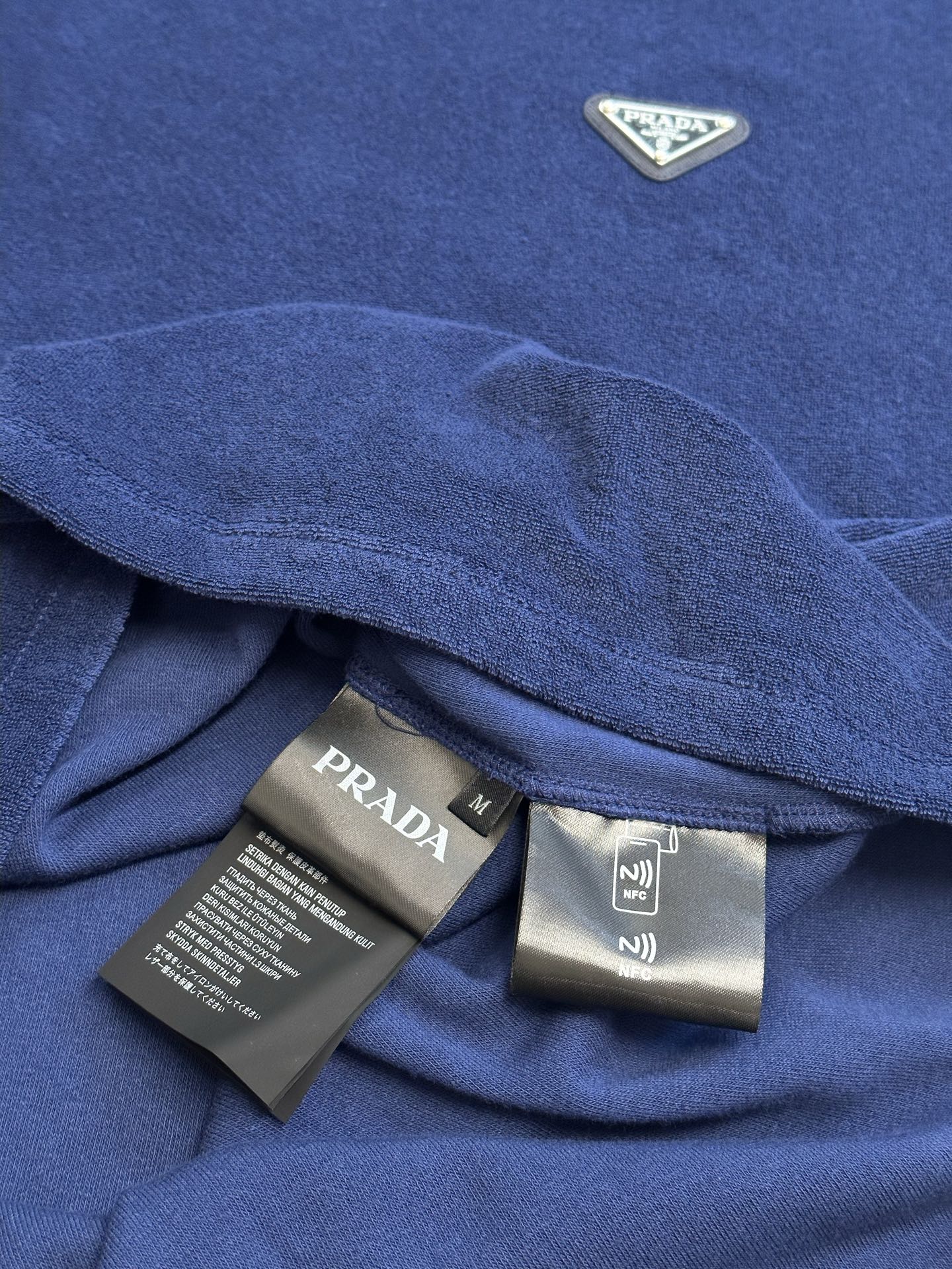 Blue T-shirt collar with Prada size label and care tags