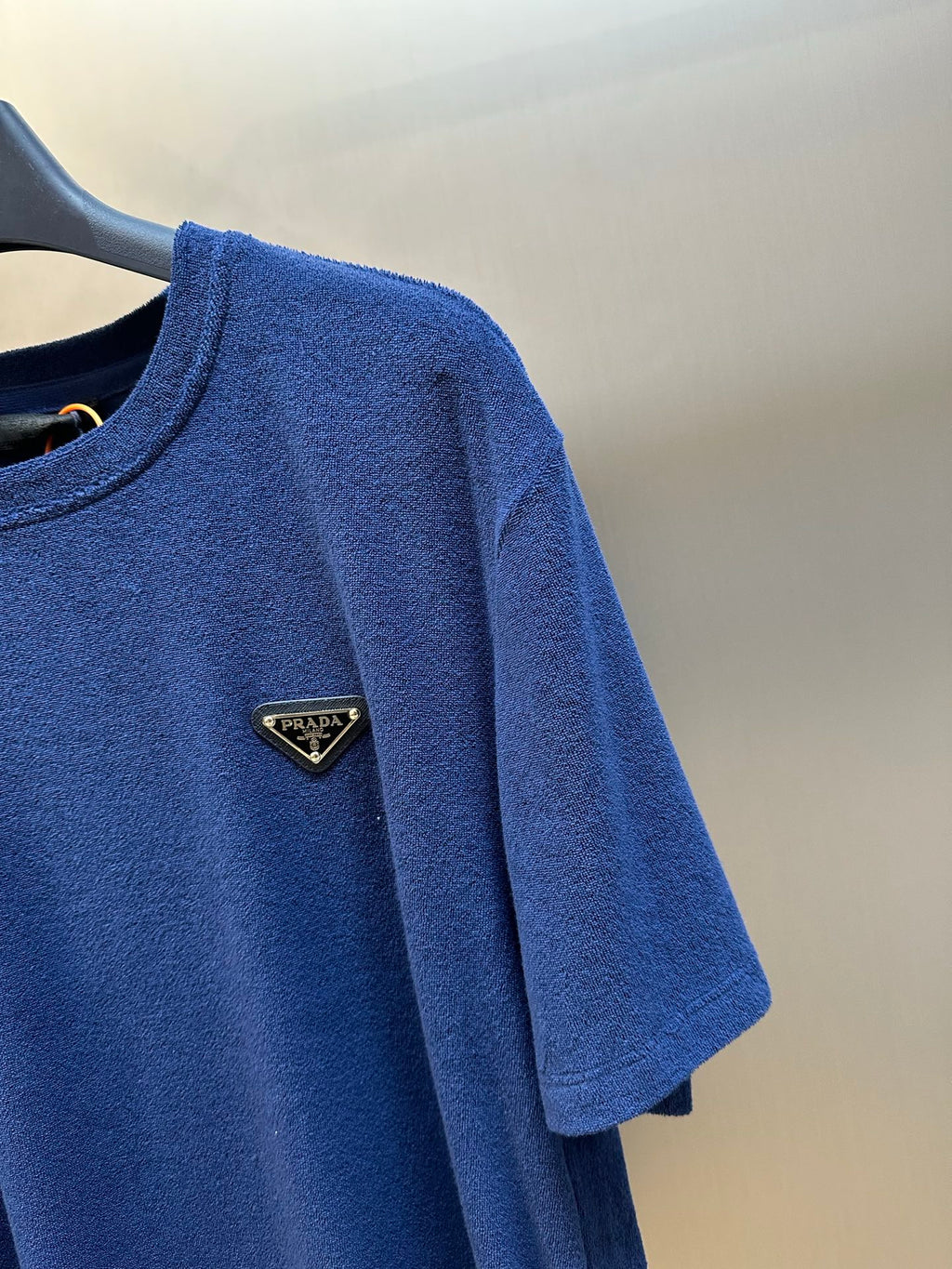 Prada short-sleeve T-shirt shoulder, blue with triangular logo patch.