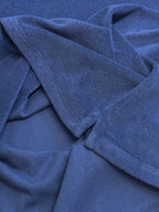 Blue Prada T-shirt fabric close-up with draped folds.