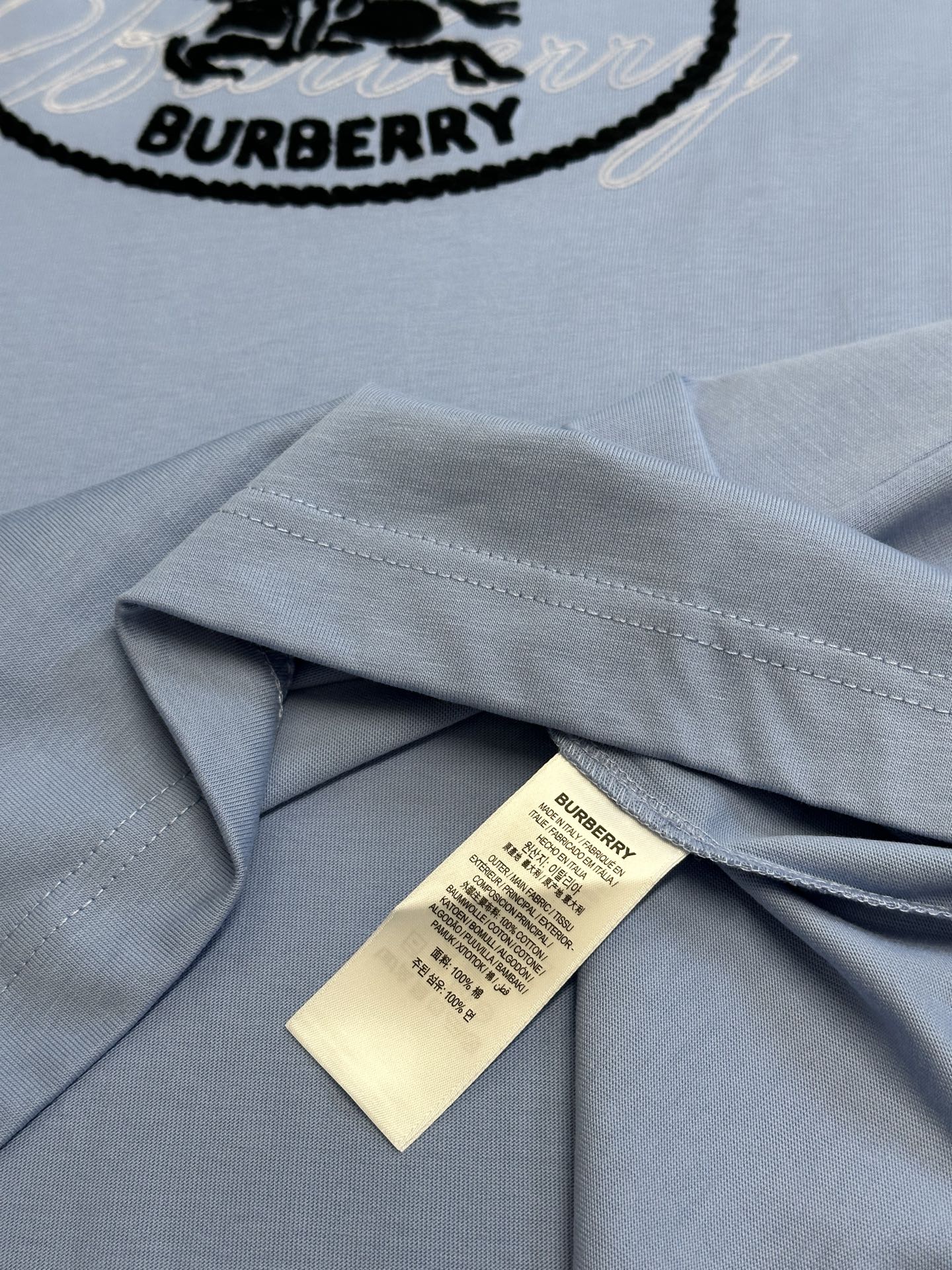 Light blue T-shirt shoulder seam with Burberry care label inside collar