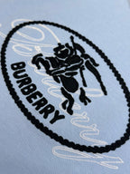 Light blue T-shirt close-up of oval Burberry logo patch
