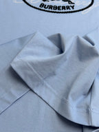 Light blue Burberry T-shirt fabric close-up with stitched hem and collar