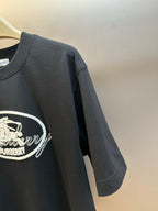 Black T-shirt sleeve with large white Burberry oval logo embroidery