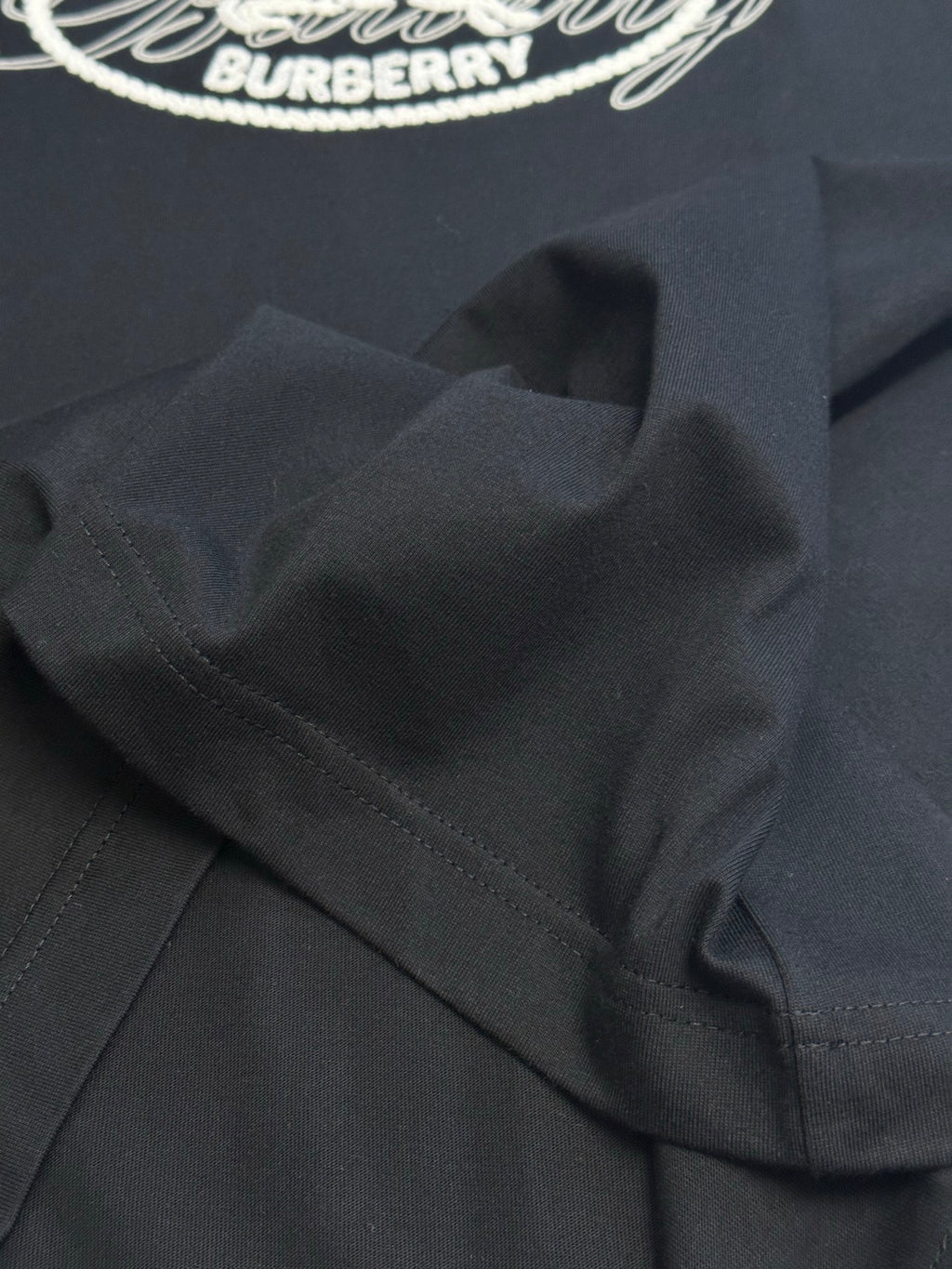 Black T-shirt shoulder seam and folded collar area