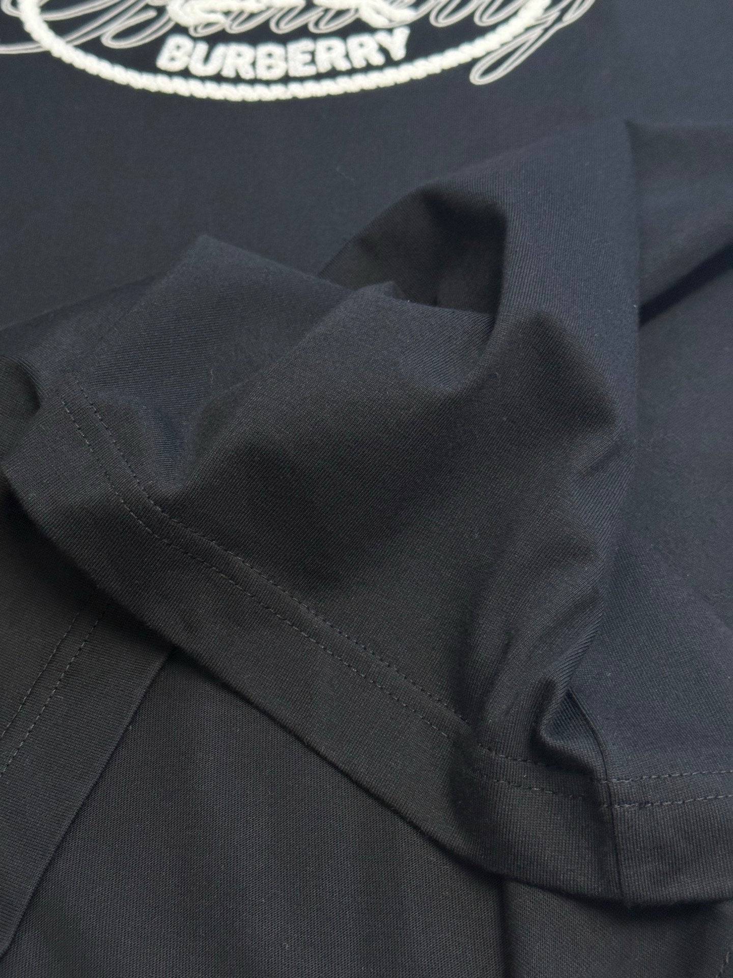 Black T-shirt shoulder seam and folded collar area