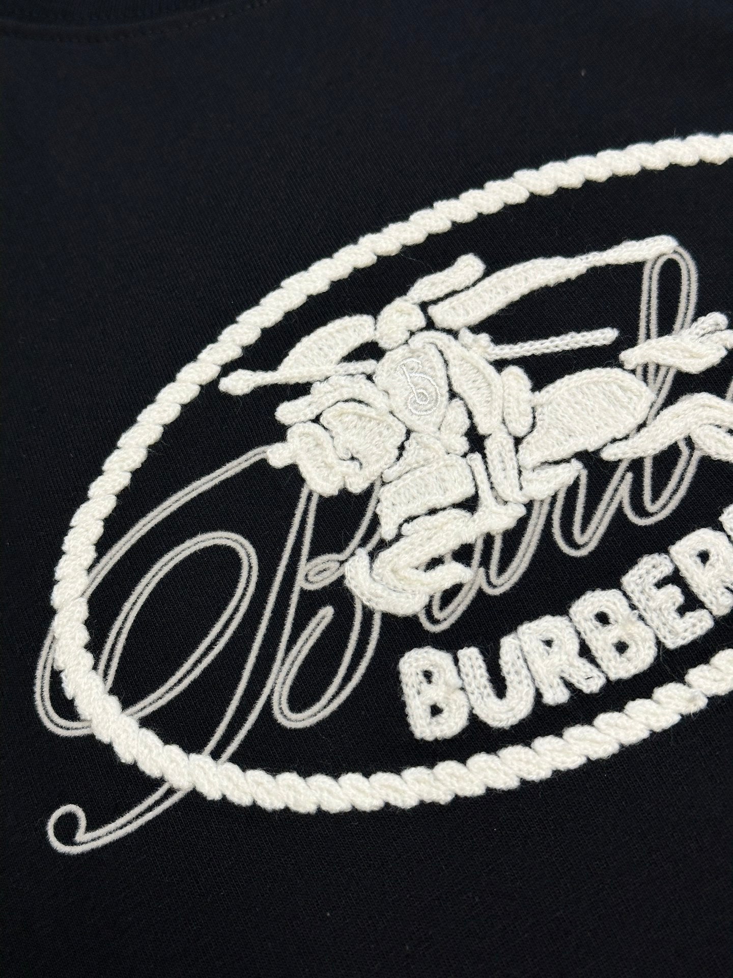 White embroidered Burberry oval crest logo on black T-shirt