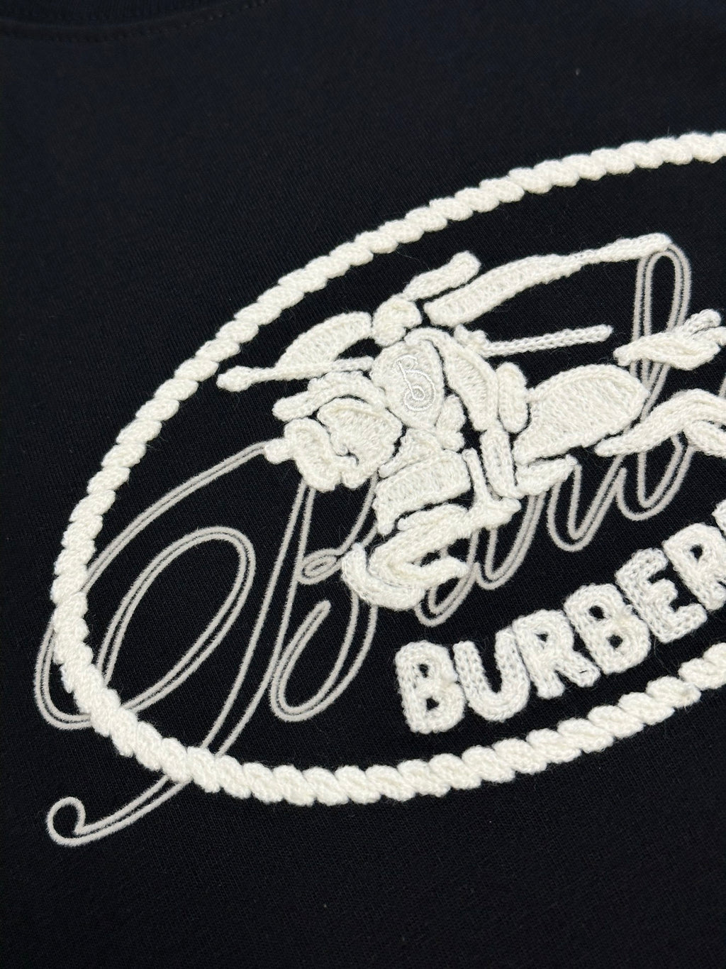 Black T-shirt with white embroidered Burberry oval logo on chest