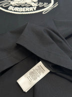 Black T-shirt fabric close-up with care label and loose fold at hem